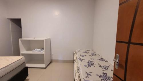 1 dormitorio con 1 cama y armario pequeño en Casa Sossego, en Caldas Novas