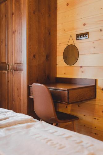 a bedroom with a desk and a chair next to a bed at Eco Village & Chalets Green Heaven in Mojkovac