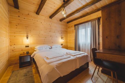 a bed in a wooden room with a piano at Eco Village & Chalets Green Heaven in Mojkovac