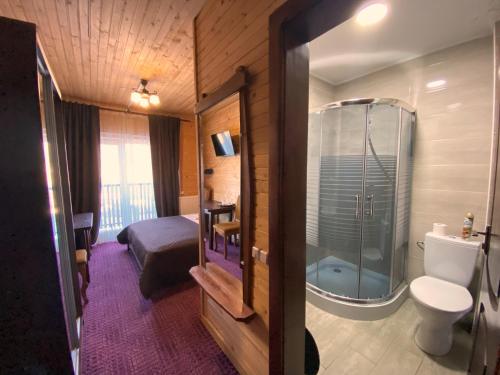 a small bathroom with a toilet and a shower at FORREST hotel in Bukovel