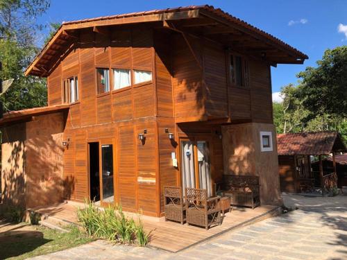 uma pequena casa de madeira com um alpendre e um alpendre em Monte Suiço - Chalés para locação em Guaramiranga