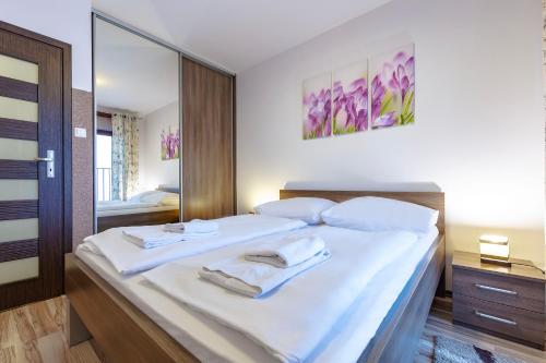 ein Schlafzimmer mit einem großen Bett mit Handtüchern darauf in der Unterkunft VacationClub – Górna Resorts Apartament 1.33 in Szklarska Poręba