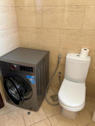 a bathroom with a toilet and a washing machine at Royal Breeze view in Ras al Khaimah