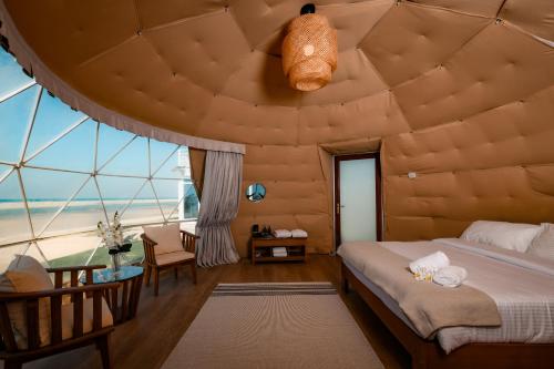 um quarto com uma ampla sala com um tecto grande em Palette Siniya Island Resorts em Umm Al Quwain