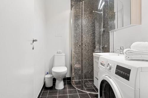 a bathroom with a toilet and a washing machine at Forenom Serviced Apartments Oslo Nobel in Oslo