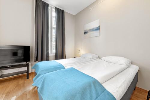 a bedroom with a large white bed and a flat screen tv at Forenom Serviced Apartments Oslo Nobel in Oslo