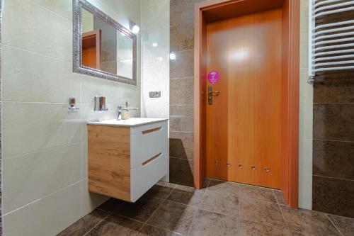 een badkamer met een wastafel, een spiegel en een douche bij VacationClub – Osiedle Podgórze 1C Apartament 5 in Szklarska Poręba