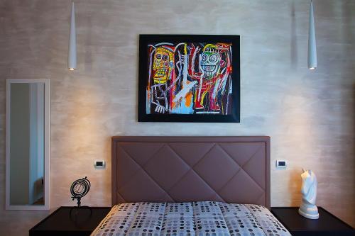 a bedroom with a bed and a painting on the wall at Ferrari Suite in Campobasso
