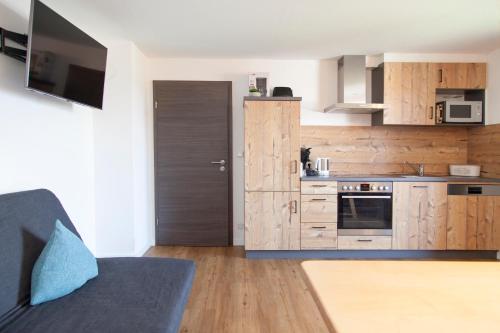 a kitchen with wooden cabinets and a blue couch in a room at Stadl Appartements in Türkheim
