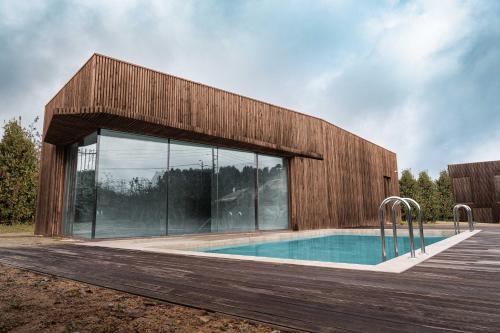 a house with a swimming pool in front of a building at Villã - Casas de Campo in Paredes