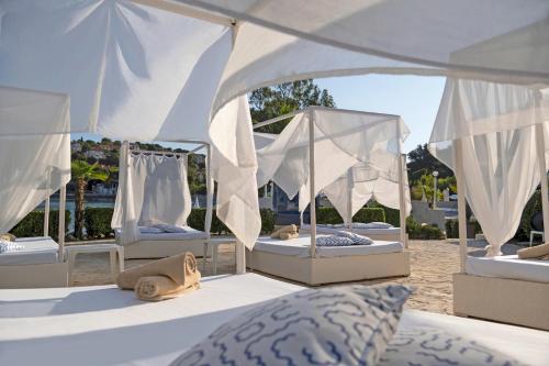 a group of four beds under a white canopy at TUI BLUE Kalamota Island - All Inclusive in Dubrovnik