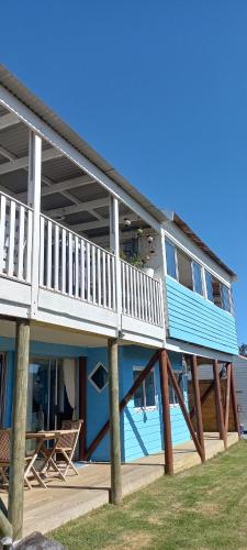 ein großes blaues Haus mit einem Balkon und einem Tisch in der Unterkunft The Blue Room in Langebaan