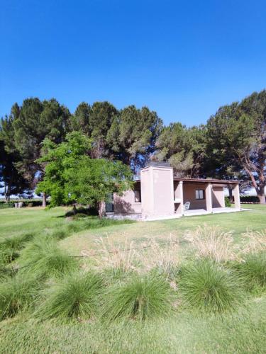 a house in the middle of a grass field at Cabañas Entre Hileras in Ciudad Lujan de Cuyo