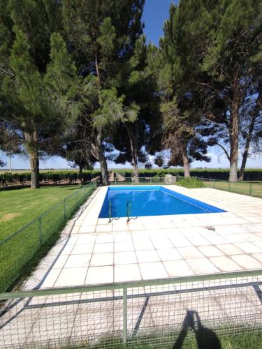 a fence around a swimming pool with trees in the background at Cabañas Entre Hileras in Ciudad Lujan de Cuyo