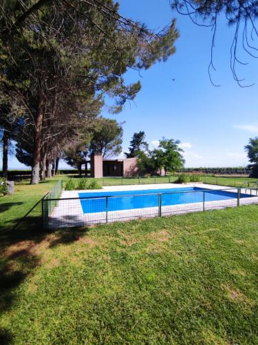 a swimming pool with a fence around it in a yard at Cabañas Entre Hileras in Ciudad Lujan de Cuyo