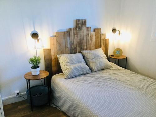 - une chambre avec un grand lit et 2 tables de chevet dans l'établissement Cabourg-La mer à vos pieds et la thalasso à 50 m, à Cabourg