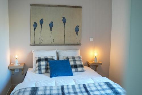 une chambre avec un lit blanc avec des oreillers bleus dans l'établissement Appartement neuf, avec terrasse, parking et ascenseur, à Saint-Valery-sur-Somme