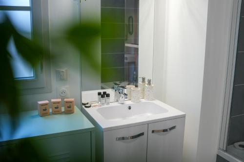 une salle de bain avec un lavabo blanc et un miroir dans l'établissement Appartement neuf, avec terrasse, parking et ascenseur, à Saint-Valery-sur-Somme