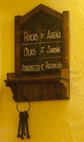 a sign on a yellow wall with a bunch of keys at Hotel Triskel in Jávea