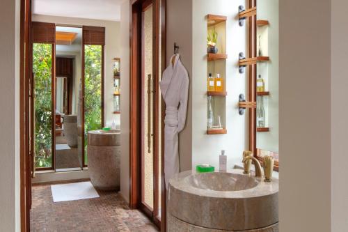 Anantara Maia Seychelles Villas في ماهي: حمام مع حوض كبير وحوض استحمام