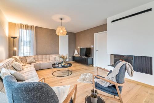 een woonkamer met een bank en een tafel bij Villa Sailing-large luxury house in quiet location in Nieuwpoort