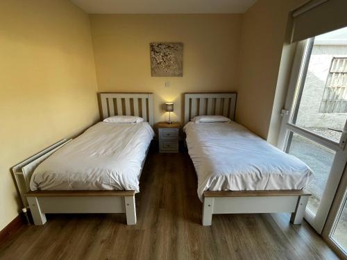 ドニゴールにあるAshdoon Houseの窓のある部屋にツインベッドが2台