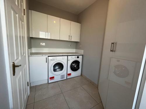 ドニゴールにあるAshdoon Houseの洗濯機と乾燥機を備えた洗濯室