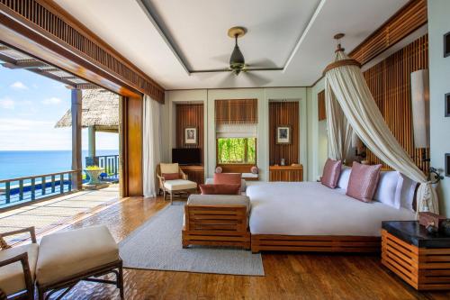 1 dormitorio con 1 cama y balcón en Anantara Maia Seychelles Villas, en Mahe
