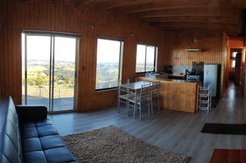 a living room with a kitchen and a counter top at Agradable y cómoda cabaña con vista espectacular in Chonchi