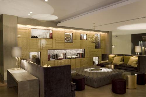 a living room filled with furniture and decor at Rosa Grand Milano - Starhotels Collezione in Milan