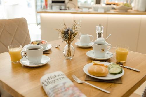 a table with plates of food and cups of coffee at Privathotel alte mühle Wolfsburg-Weyhausen in Wolfsburg