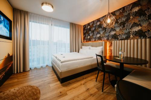 una camera d'albergo con letto e tavolo di Rioca Neu-Ulm Posto 5 a Neu-Ulm