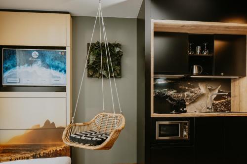 a hanging chair in a room with a tv at Rioca Neu-Ulm Posto 5 in Neu Ulm