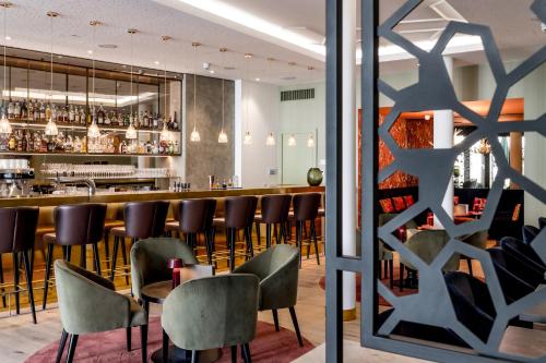 施萬高的住宿－AMERON Neuschwanstein Alpsee Resort & Spa，餐厅内的酒吧配有椅子和柜台