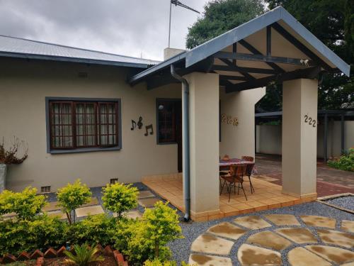 Casa con terraza de madera y mesa en Cozy Manor Guestrooms, en Lyttelton