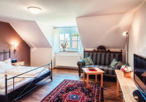 ein Wohnzimmer mit einem Bett und einem Sofa in der Unterkunft Pension Sankt Urban in Sommerach