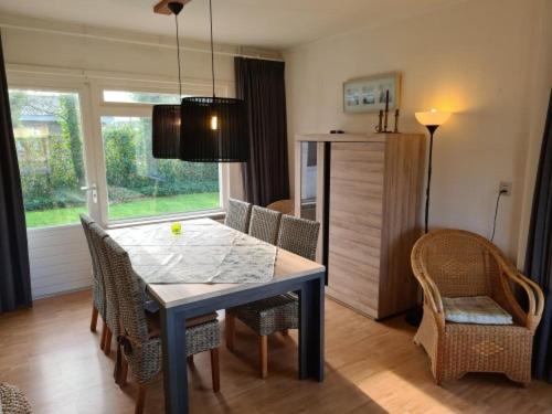 a dining room with a table and chairs and a kitchen at Jadi in Cadzand