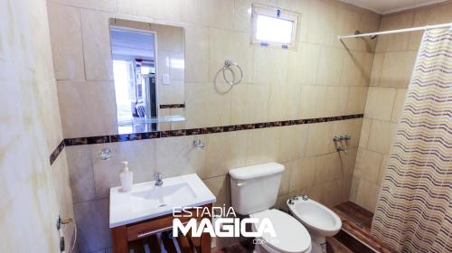 uma casa de banho com um lavatório, um WC e um espelho. em Quinta Aires em San Rafael