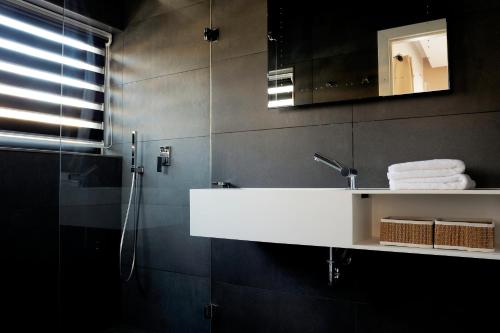 ein Badezimmer mit einem weißen Waschbecken und einem Spiegel in der Unterkunft Luxueux Domaine Dal Cayrou grande piscine Cahors in Cahors