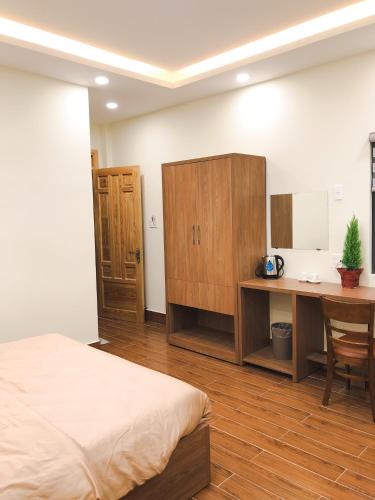 a bedroom with a bed and a desk and a table at Anita homestay Dalat in Khu Chi Lăng