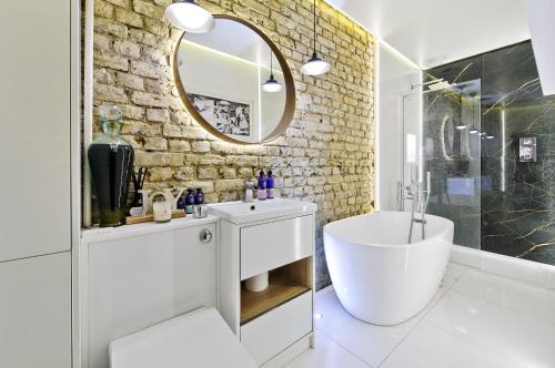 a bathroom with a white sink and a mirror at Stunning one bedroom flat with large terrace in Chiswick by UnderTheDoormat in London