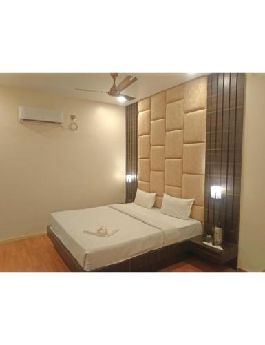 1 dormitorio con 1 cama con colcha blanca en Hotel New Grand, Deoghar en Deoghar