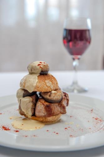 a stack of pastries on a plate with a glass of wine at Kipriotis Panorama Hotel & Suites in Kos Town