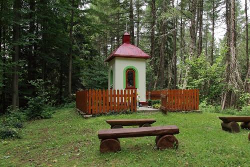 a small house with a red roof and a picnic table at Ski Apartmán Sajmon so saunou in Makov