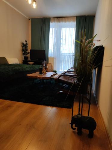 a living room with a bed and a table with a plant at Ski Apartmán Sajmon so saunou in Makov
