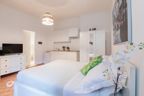 a white bedroom with a white bed and a tv at Duomo Central Studio in Florence