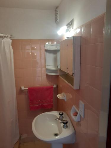 baño con lavabo y toalla roja en alquiler temporario en Rosario