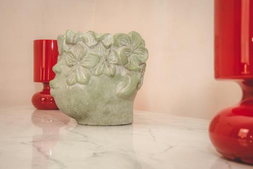 a green vase sitting on a table next to two red vases at Lunà - Le Dimore - in Canosa di Puglia