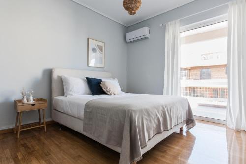 1 dormitorio con cama y ventana en Enjoyable 2BR Apartment in Marousi by UPSTREET en Athens