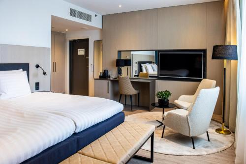 - une chambre avec un lit, un bureau et une télévision dans l'établissement Hotel Matts, à Espoo